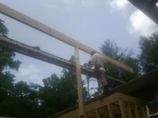 Carpenter setting a ridge beam over a new addition frame — Ice Dam Removal by Roofing Brothers in Fruitvale