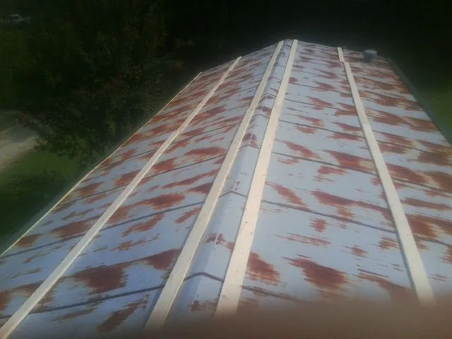 Rusted metal roof panels with new wood purlins before replacement — Storm Damage Roof Repair in Fruitvale by Roofing Brothers